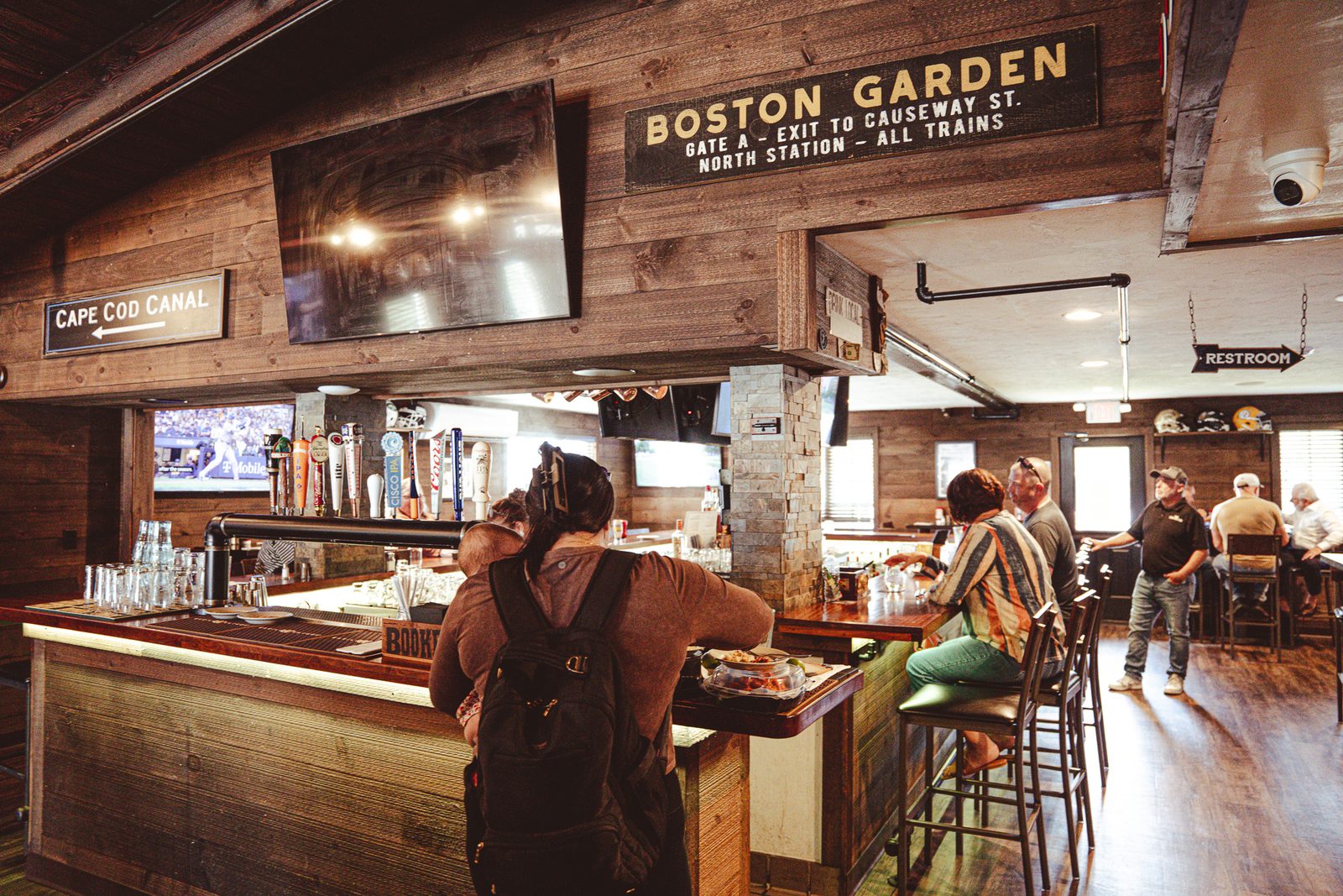 The bar at Michael's Village Pub, with tap handles and a Boston Garden sign