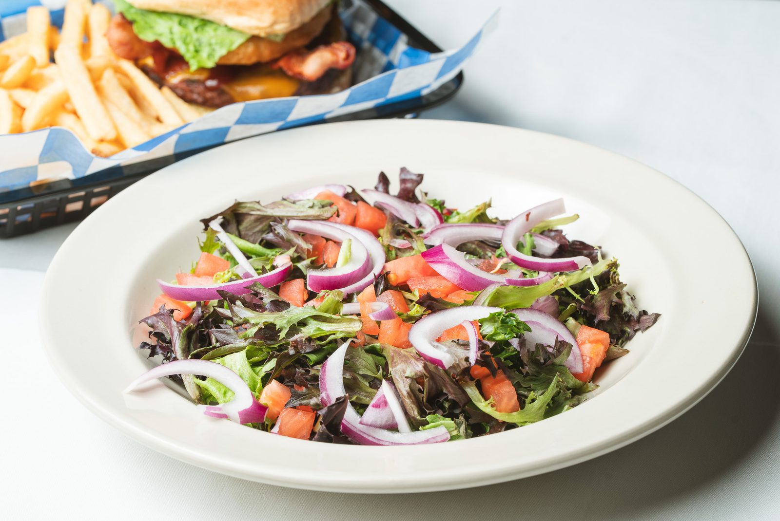 A house salad of mixed greens, tomato, and red onion